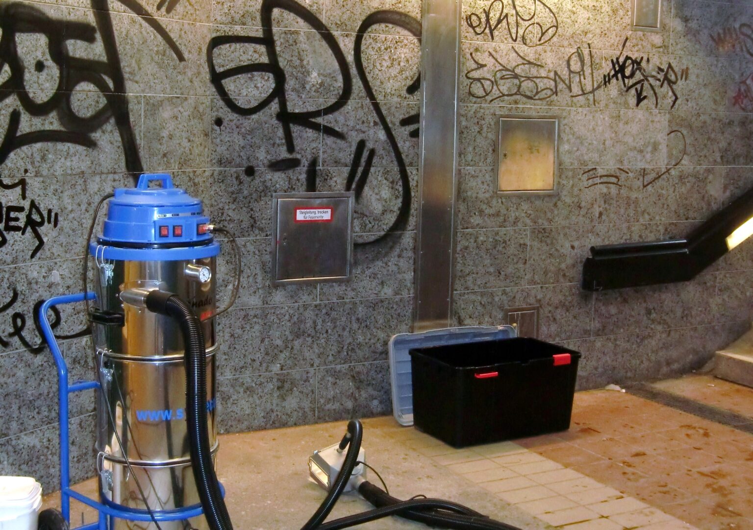 Tornado ACS 35 vor einer besprühten Granitwand in einer Münchner Unterführung, Schlauchpaket und Auffangbehälter stehen bereit